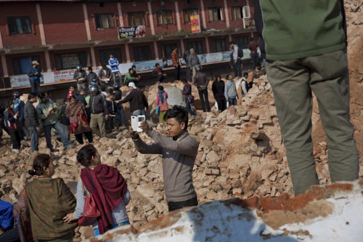 A man takes a selfie at the historic Dharahara Tower, a city landmark, that was damaged in Saturdays earthquake in Kathmandu, Nepal, Monday, April 27, 2015. A strong magnitude earthquake shook Nepals capital and the densely populated Kathmandu valley on Saturday devastating the region and leaving tens of thousands shell-shocked and sleeping in streets. (AP Photo/Bernat Armangue)