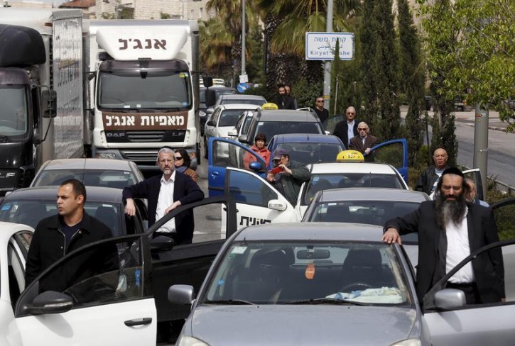 Motorists stand still beside vehicles as a two-minute siren marking Holocaust Remembrance Day is sounded in Jerusalem April 16, 2015. Israel on Thursday marks its annual memorial day commemorating the six million Jews killed by the Nazis during World War Two.    REUTERS/Baz Ratner 