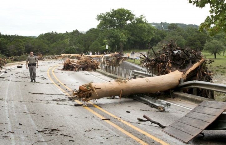 Department of Public Safety Trooper Marcus Gonzales walks on the Highway 12 bridge over the Blanco River which was blocked by large trees after flooding in Wimberly, Texas, United States May 24, 2015. REUTERS/Jay Janner/American-Statesman