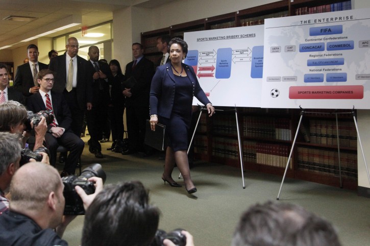 Attorney General Loretta E. Lynch, center, arrives for a news conference to announce an indictment against nine FIFA officials and five corporate executives for racketeering, conspiracy and corruption, Wednesday, May 27, 2015, in the Brooklyn borough of New York. Nine of the 14 that were indicted by the Justice Department are soccer officials, while four are sports marketing executives and another works in broadcasting. (AP Photo/Mark Lennihan)