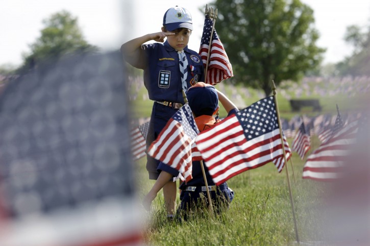 Cub Scout Tristan Swanhart, 8, of Cookstown, N.J., salutes after placing a flag on a grave, as scouts placed thousands of flags on veterans graves at Brig. Gen. William C. Doyle Veterans Memorial Cemetery in honor of Memorial Day Friday, May 22, 2015, in Wrightstown, N.J. (AP Photo/Mel Evans)