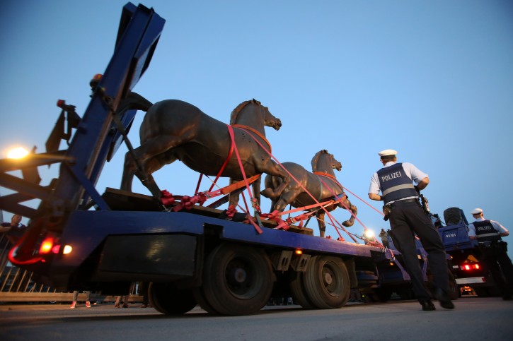 Two bronze horse statues by artist Josef Thorak are transported on a flatbed trailer in Bad Duerkheim, southwestern Germany, Thursday, May 21, 2015. A German investigation into black market art had recovered the two statues that once stood in front of Adolf Hitler's grand chancellery building in Berlin as well as other Nazi-era pieces that had been lost for decades. Police in five states conducted coordinated raids during more than a yearlong investigation into illegal art trafficking. (Fredrik von Erichsen/dpa via AP)