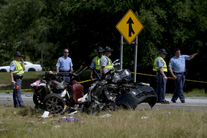 Multiple police officers  investigate a car involved in a multiple car accident on I-16 in Pooler, Ga. on Tuesday, May 19, 2015. (Ian Maule/Savannah Morning News via AP) 