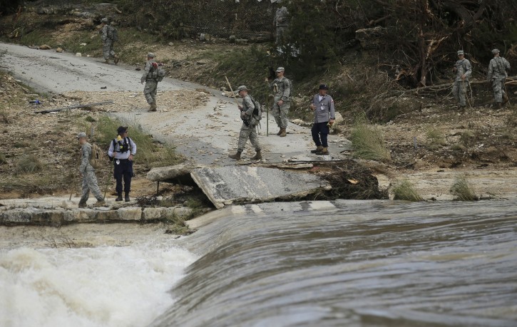 Members of the National Guard and a search and rescue team work along the Blanco River, Tuesday, May 26, 2015, in Wimberley, Texas.