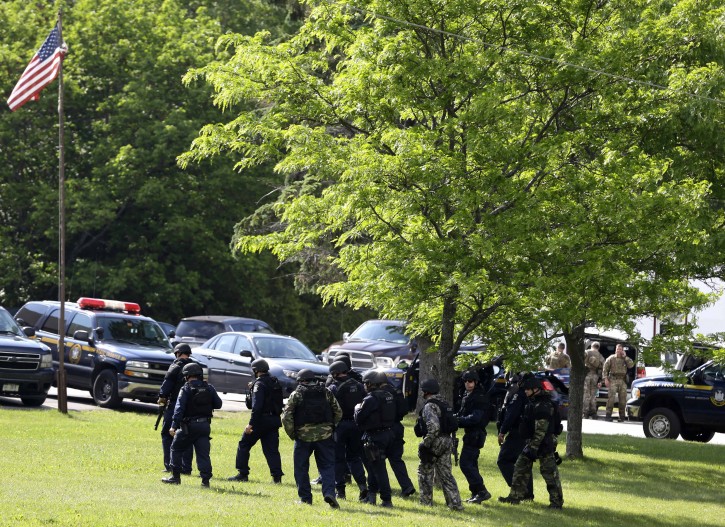 Heavily armed law enforcement officers stand near an area during a search for two escaped prisoners near Dannemora, N.Y., Thursday, June 11, 2015. Police have blocked off the main road outside a northern New York village as authorities concentrate their sixth day of searching for David Sweat and Richard Matt on a swampy area just a couple miles from the prison the convicts broke out of last weekend. (AP Photo/Seth Wenig)