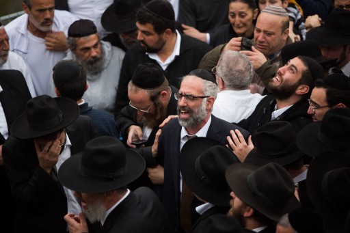 FILE - Gabriel Sassoon reacts near the fresh graves of his seven children during thier funeral in Jerusalem on March 23, 2015. Flash90