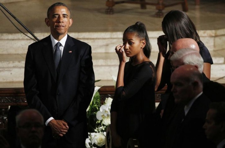 U.S. President Barack Obama watches, and his daughter Sasha and first lady Michelle Obama wipe away tears, as the casket of former Delaware Attorney General Beau Biden, son of Vice President Biden, leaves his funeral at St. Anthony of Padua church in Wilimington, Delaware June 6, 2015.  REUTERS/Kevin Lamarque