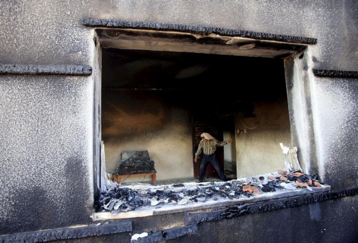 A Palestinian man inspects a house that was badly damaged in a suspected attack by Jewish extremists on two houses at Duma village near the West Bank city of Nablus July 31, 2015. Suspected Jewish extremists set fire to a Palestinian home in the occupied West Bank on Friday, killing an 18-month-old baby and seriously injuring several other family members, an act that Israel's prime minister described as terrorism. REUTERS/Abed Omar Qusini