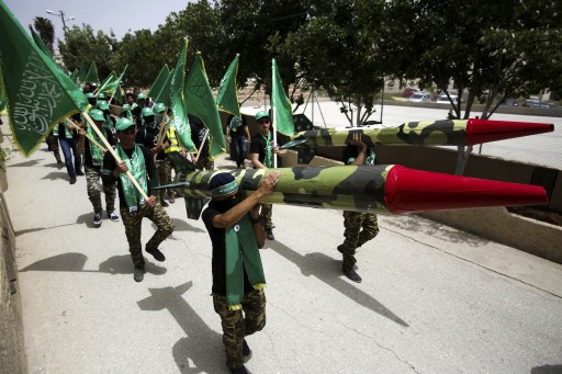 Palestinian students supporters of the Islamic militant movement of Hamas march with mock missiles, in the West Bank city of Hebron. EPA/ABED AL HASLHAMOUN