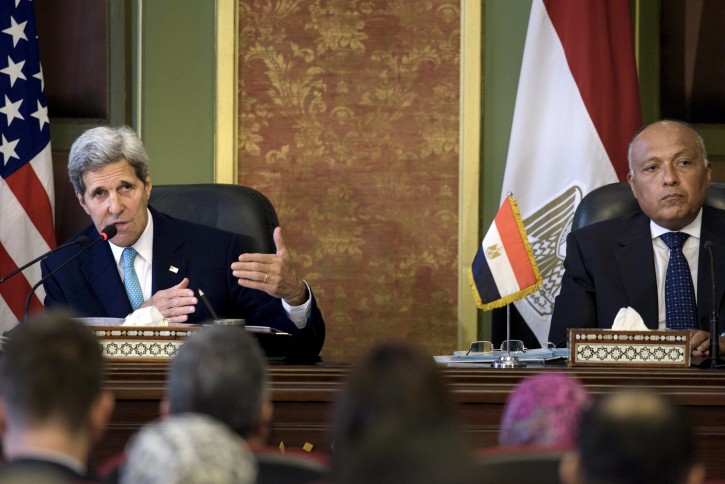 Egyptian Foreign Minister Sameh Shukri (R) listens as U.S. Secretary of State John Kerry delivers a speech during a news conference after meetings at the Ministry of Foreign Affairs in Cairo August 2, 2015. Kerry said on Sunday the United States and Egypt were moving back to a "strong base" in their relationship despite tensions and concerns on human rights. REUTERS/Brendan Smialowski/Pool