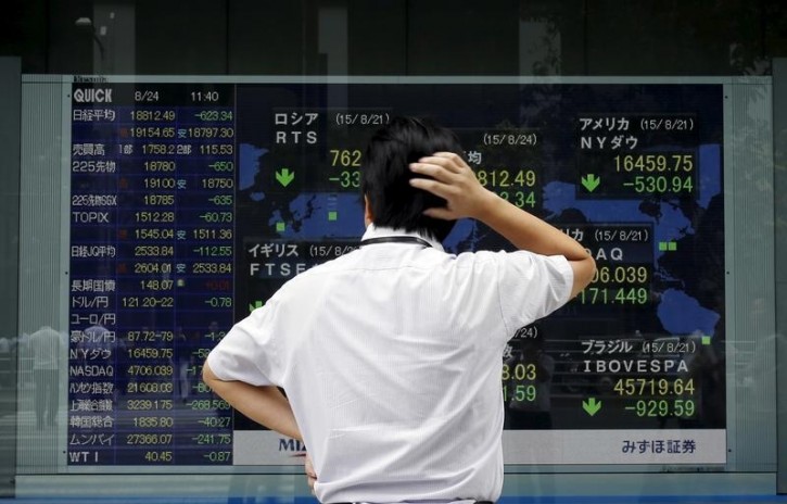 A man looks at a stock quotation board outside a brokerage in Tokyo, August 24, 2015. Asian stocks dived to 3-year lows on Monday as a rout in Chinese equities gathered pace, hastening an exodus from riskier assets as fears of a China-led global economic slowdown roiled world markets.  REUTERS/Toru Hanai  - 