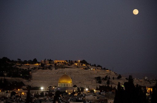FILE - A supermoon rises over Jerusalem's Old City seen from the roof restaurant of the Notre Dame hotel. (AP Photo/Dusan Vranic, File)