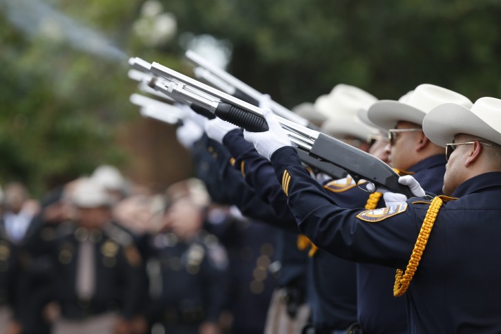 An honor guard offers a twenty-one gun salute after the funeral service for Harris County Sheriff's Deputy Darren Goforth at Second Baptist Church, Friday, Sept. 4, 2015, in Houston. Goforth was killed a week ago while filling his patrol car with gasoline at a suburban Houston convenience store. A 30-year-old Houston man is charged with his slaying. (Steve Gonzales/Houston Chronicle via AP)