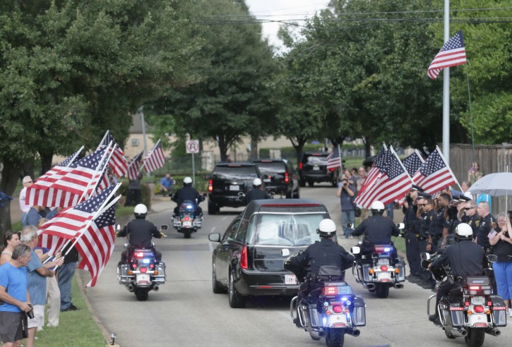 The funeral procession for slain Harris County Sheriff's Deputy Darren Goforth makes its way along Antoine Drive Friday, Sept. 4, 2015, in Houston. Goforth was killed a week ago while filling his patrol car with gasoline at a suburban Houston convenience store. A 30-year-old Houston man is charged with his slaying. (Jon Shapley/Houston Chronicle via AP) 