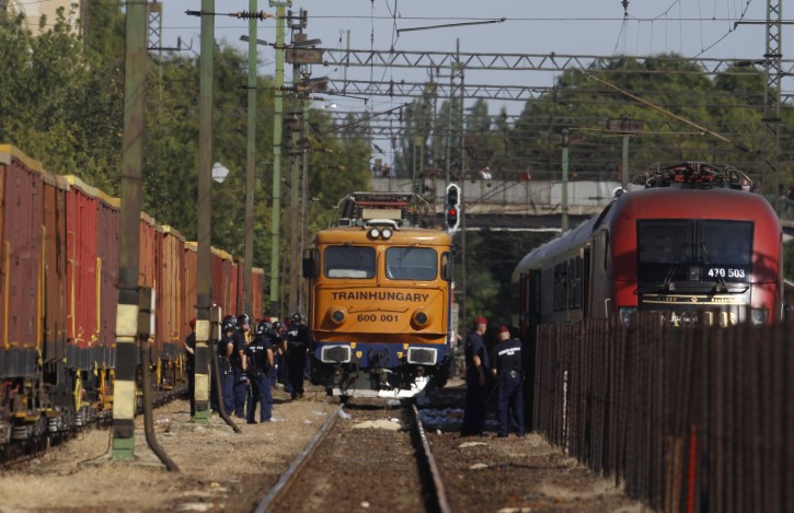 Police try to secure a train that was stopped in Bicske, Hungary, Friday, Sept. 4, 2015. Over 150,000 migrants have reached Hungary this year, most coming through the southern border with Serbia. Many apply for asylum but quickly try to leave for richer EU countries. (AP Photo/Petr David Josek)