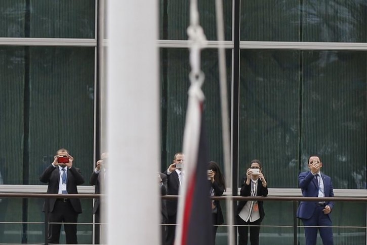 Onlookers take photographs as the Palestinian flag is being raised by Palestinian President Mahmoud Abbas (not pictured) in a ceremony outside the United Nations during the 70th session of the U. N. General Assembly in New York, September 30, 2015. Even though Palestine is not a member of the United Nations, the General Assembly adopted a Palestinian-drafted resolution that permits non-member observer states to fly their flags alongside those of full member states.  REUTERS/Carlo Allegri 