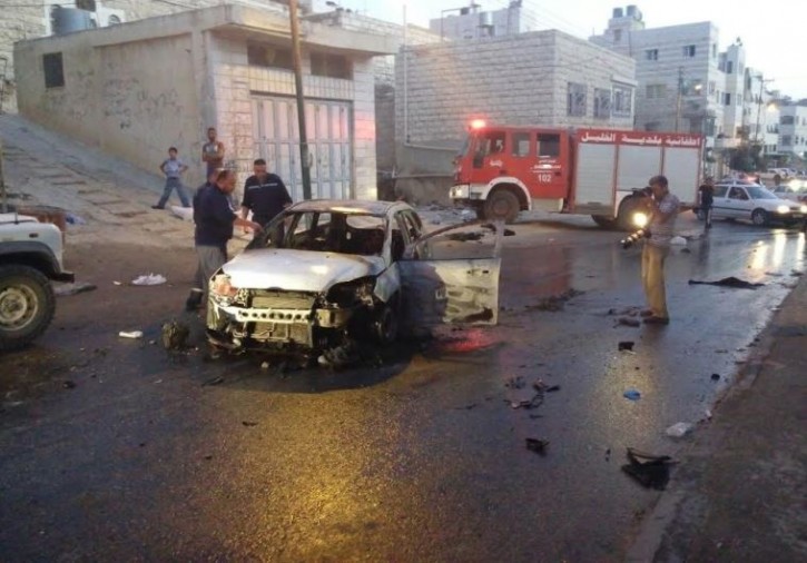 Police gather around a burned out vehicle used by US tourists after it was attacked by Palestinians in the West Bank city of Hebron, 03 September 2015.