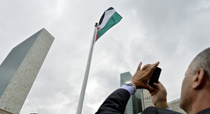 A man takes a picture of the Palestinian flag flying over United Nations headquarters in New York, New York, USA, 30 September 2015. EPA