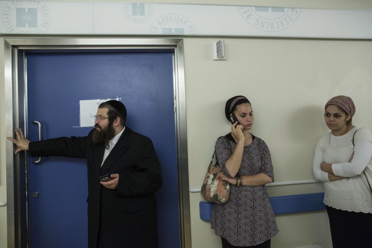 In this Monday, Oct. 12, 2015 photo, friends and relatives of Odel Bennett stand outside her room at the Hadassah Medical Center in Jerusalem. (AP Photo/Tsafrir Abayov)