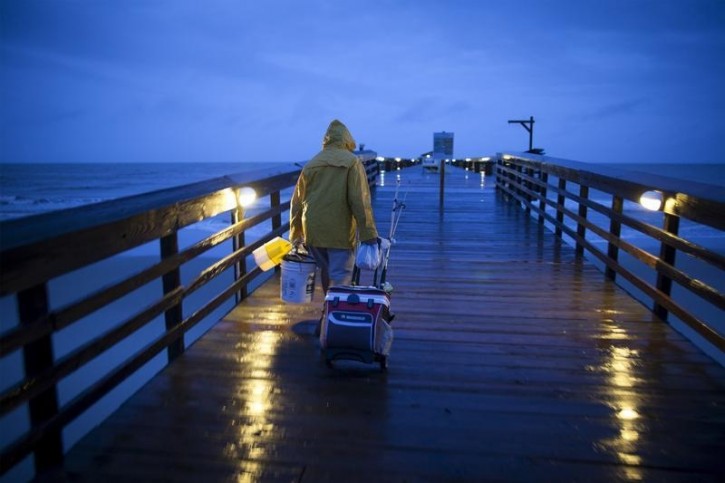Fisherman Dominick Manfredini prepares to fish at daybreak at the pier at Myrtle Beach State Park as heavy rain falls in Myrtle Beach, South Carolina, October 2, 2015. Reuters