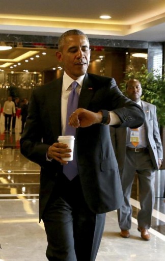 File: U.S. President Barack Obama checks the time on his way to a meeting. (Anadolu Agency via AP, Pool)