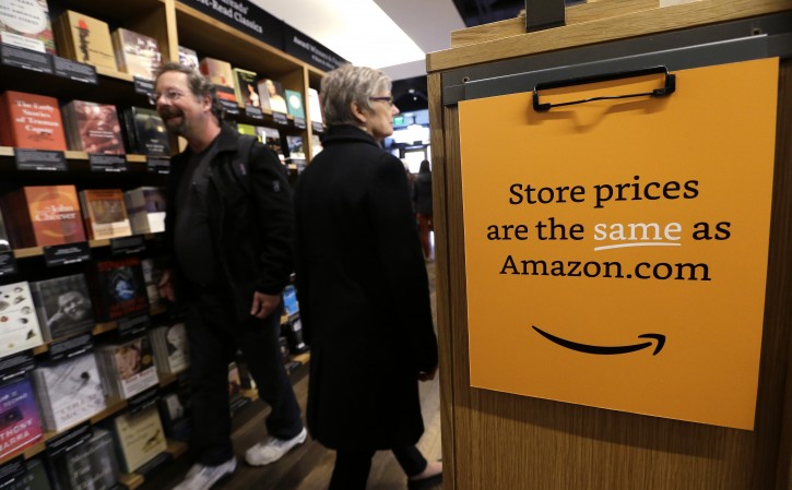 FILE - Customers shop at the opening day for Amazon Books, the first brick-and-mortar retail store for online retail giant Amazon, Tuesday, Nov. 3, 2015, in Seattle. (AP Photo/Elaine Thompson)