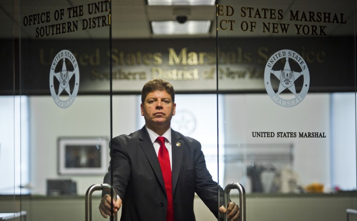 U.S. Marshall Director Michael Greco pose at the entrance to his office, Thursday, Oct. 8, 2015, in New York.  Greco was recently named the first Hispanic U.S. marshal in the judicial district that includes Manhattan.(AP Photo/Bebeto Matthews)