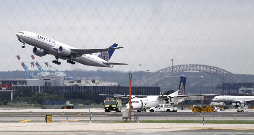 FILE - In this July 25, 2013 file photo, a United Airlines plane, top left, takes off from Newark Liberty International Airport, in Newark, N.J. (AP Photo/Julio Cortez)