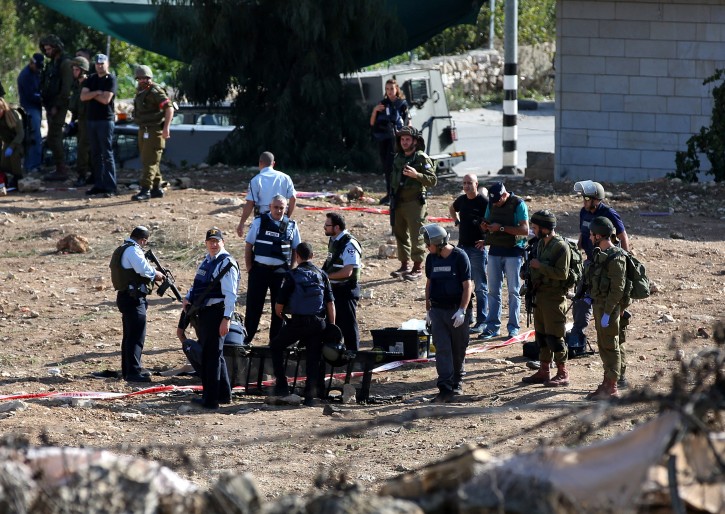  Israeli soldiers and police inspect the body of a dead Palestinian named Fadi al-froukh from the West Bank town of Sa'air near Hebron, 01 November 2015. Froukh was shot dead after trying to  stab an Israeli soldier at the entrance of Sa'air village, Israeli news sources reported.  EPA/ABED AL HASHLAMOUN