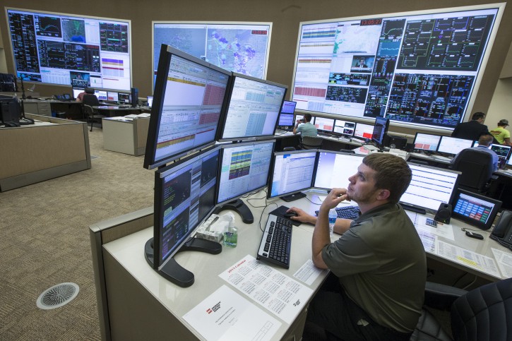 In this Wednesday, May 20, 2015 photo, system control center operator Ryan Cox sits at his computer workstation at an AEP Transmission Operations Center in New Albany, Ohio. Like most big utilities, AEP's power plants, substations and other vital equipment are managed by a network that is separated from the companys business software with layers of authentication, and is not accessible via the Internet. Creating that separation, and making sure that separation is maintained, is among the most important things utilities can do to protect the grid's physical assets. (AP Photo/John Minchillo)