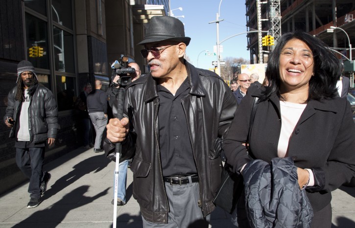 William Vasquez, center, walks outside the courthouse with his attorney, Rita Dave, after a judge overturned his conviction, Wednesday, Dec. 16, 2015, in New York.  Vasquez was convicted of arson and six murders with two other defendants after a 1981 trial. Brooklyn District Attorney Ken Thompson asked the judge to clear the men. He says they were convicted based on outdated fire science and a lying witness. (AP Photo/Mark Lennihan)
