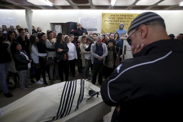 Friends and relatives mourn near the body of Ofer Ben Ari, 46, who was killed by Israeli police gunfire aimed at two Palestinian stabbers on Wednesday, during his funeral in Jerusalem December 24, 2015.  REUTERS/Baz Ratner 