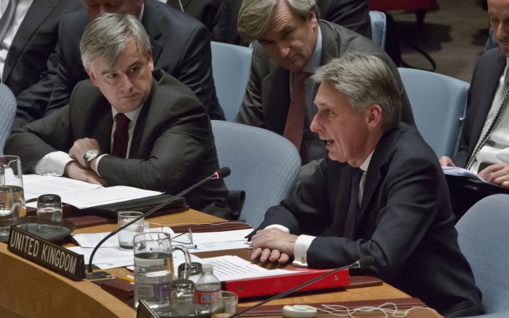 Spain Deputy Foreign Minister Ignacio Ybañez, left, listens as United Kingdom Foreign Minister Philip Hammond, right, addresses a gathering in the U.N. Security Council of foreign ministers following a vote on a draft resolution concerning Syria, Friday, Dec. 18, 2015, at U.N. headquarters. (AP Photo/Bebeto Matthews)