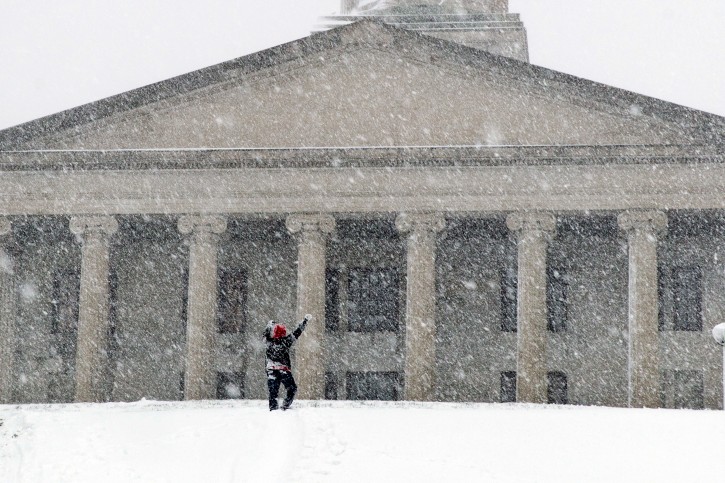 A man celebrates making it up a steep, snow-covered hill north of the state Capitol in Nashville, Tenn., on Friday, Jan. 22, 2016. Much of downtown was deserted as state and city government offices were closed for the day. (AP Photo/Erik Schelzig)
