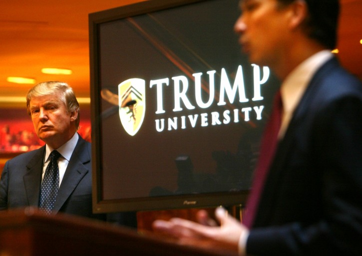 FILE - In this May 23, 2005 file photo, Donald Trump, left, listens as Michael Sexton, president and co-founder of the business education company, introduces him to announce the establishment of Trump University at a press conference in New York.  Long before Trumps seductive mix of optimism and hyperbole proved a success on the campaign trail, it exerted a powerful tug on middle class folks involved in three companies he promoted as way for them to build wealth.  (AP Photo/Bebeto Matthews)