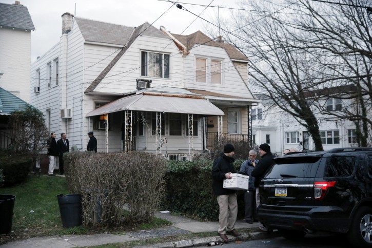 An investigator takes a box from one of the residences where suspect Edward Archer has lived Friday, Jan. 8, 2016, in Yeadon, Pa. Archer accused of ambushing a police officer and firing shots at point-blank range said he was acting in the name of Islam and had pledged allegiance to the Islamic State group, Philadelphia authorities said Friday. (AP Photo/Matt Rourke)