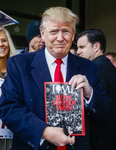 Republican presidential candidate Donald Trump holds a copy of TIME magazine as he greets supporters during a campaign appearance at the John Wayne Museum in Winterset, Iowa, 19 January 2016.  EPA