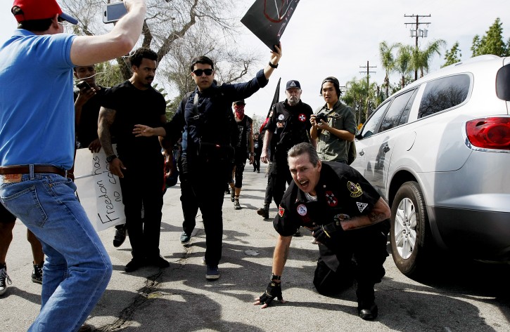 Counter protesters taunt an injured Ku Klux Klansman after members of the KKK tried to start a "White Lives Matter" rally at Pearson Park in Anaheim on Saturday, Feb. 27, 2016. The event quickly escalated into violence and at least two people had to be treated at the scene for stab wounds. (Luis Sinco/Los Angeles Times via AP)