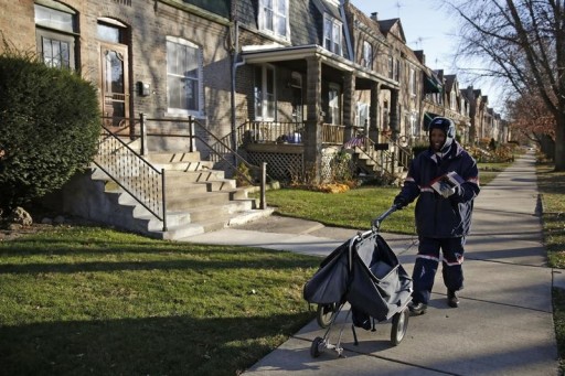 FILE - Mail carrier Marissa Ogletree delivers mail in the historic Pullman neighborhood in Chicago November 20, 2014. REUTERS