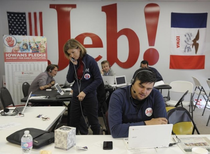 Workers for the campaign of U.S. Republican presidential candidate Jeb Bush talk on the phone in their Iowa headquarters in Des Moines, February 1, 2016. REUTERS/Dave Kaup