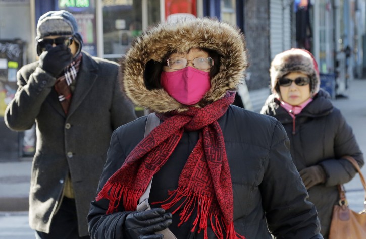 People are bundled up as they walk in cold weather, Sunday, Feb. 14, 2016, in the Queens borough of New York. Bitter temperatures and biting winds had much of the northeastern United States bundling up this weekend. (AP Photo/Mark Lennihan)