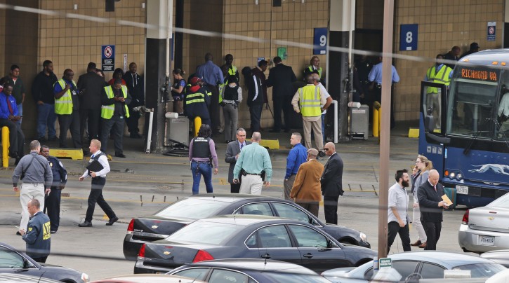 Police and rescue officials mingle with bus patrons outside the Greyhound Bus Station on Thursday, March 31, 2016, in Richmond, Va. Virginia State Police said at least two troopers responding to a shooting at the Richmond bus station and civilian have been taken to a hospital. A police spokeswoman says the shooting suspect was in custody. (AP Photo/Steve Helber)