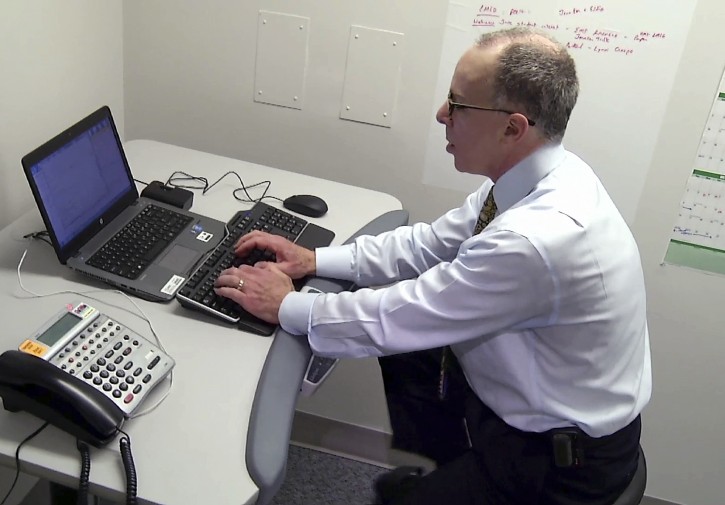 In this Friday, March 4, 2016 still photo from video, physician Dr. Edward Phillips pedals on a stationary bike that's integrated into his office desk in Boston. Phillips said exercise is "like taking a little bit of Prozac, an antidepressant,and a little bit of Ritalin, which is a stimulant." (AP Photo/Rodrique Ngowi)