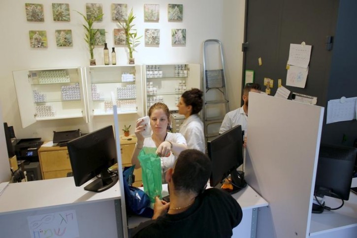 An employee serves a client at a dispensary belonging to Tikun Olam, Israel's largest medical marijuana supplier, in Tel Aviv March 27, 2016.REUTERS/Ronen Zvulun