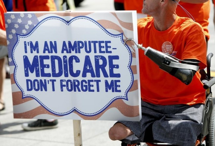 FILE - William Kidwell, a triple amputee and member of the Amputee Coalition and the American Orthotic & Prosthetic Association, protests at a rally in front of the Department of Health and Human Services in Washington, August 26, 2015. Reuters
