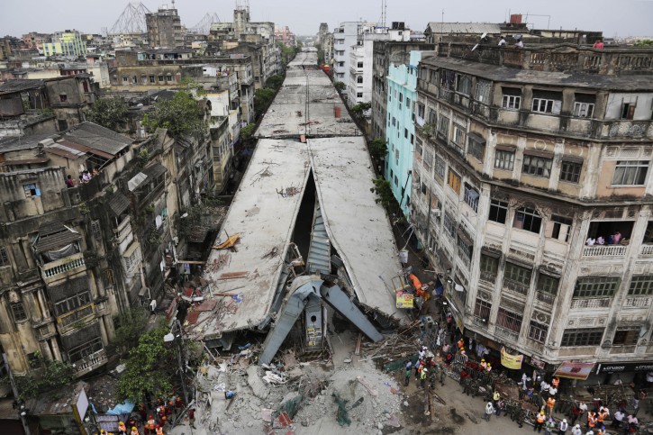 General view shows a partially collapsed overpass in Kolkata, India, Friday, April 1, 2016. The overpass spanned nearly the width of the street and was designed to ease traffic through the densely crowded Bara Bazaar neighborhood in the capital of the east Indian state of West Bengal. About 100 meters (300 feet) of the overpass fell, while other sections remained standing. (AP Photo/Bikas Das)