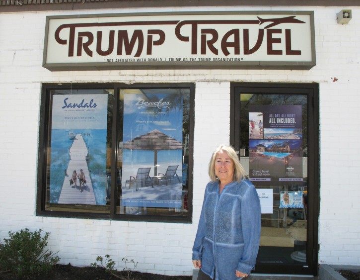 In this April 6, 2015 photo, Claudia Rabin-Manning stands outside her Baldwin, N.Y. business, Trump Travel. Rabin-Manning says she has been the target of legal action from Republican presidential candidate Donald Trump over the use of the name Trump Travel. She explains the business name has nothing to do with the businessman, and instead was named by a previous owner of the travel agency who played canasta, where the "trump card" is used in the game. (AP Photo/Frank Eltman)
