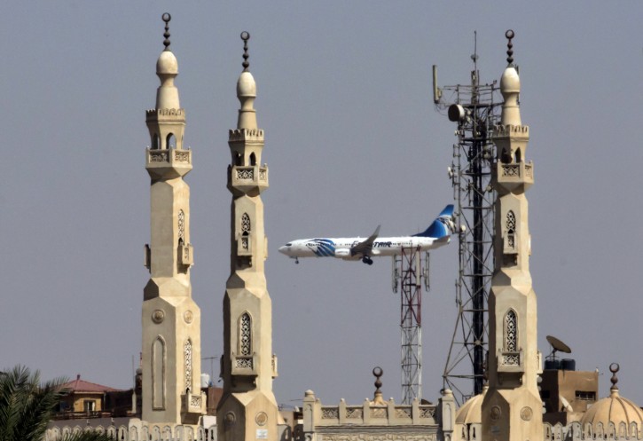 An EgyptAir flight plane flies in front of minarets of a mosque as it prepares for landing near Cairo airport, in Cairo, May, 21, 2016. Smoke was detected in multiple places on EgyptAir flight 804 moments before it plummeted into the Mediterranean, but the cause of the crash that killed all 66 on board remains unclear, the French air accident investigation agency said on Saturday. (AP Photo/Amr Nabil)
