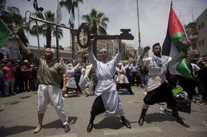 Palestinians act in a play enacting "Nakba" or Catastrophe day in the West Bank city of Ramallah, Sunday, May 15, 2016. Palestinians marked the 68th anniversary of their displacement following the Israeli declaration of independence in 1968. (AP Photo/Majdi Mohammed)