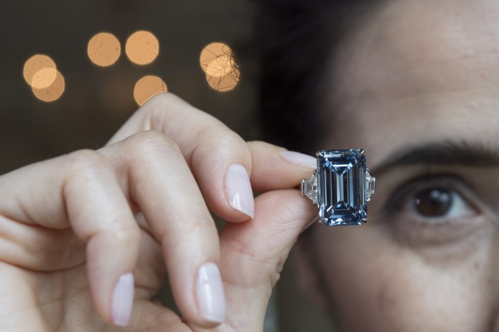 A Christie's employee holds Oppenheimer Blue diamond of 14.62 carats, which is estimated to be sold between 38,000,000 to 45,000,000 US Dollar, during a preview at the auction house Christie's, in Geneva, Switzerland, Thursday, May 12, 2016. The auction will take place on May 18, 2016 in Geneva. (Martial Trezzini/Keystone via AP)